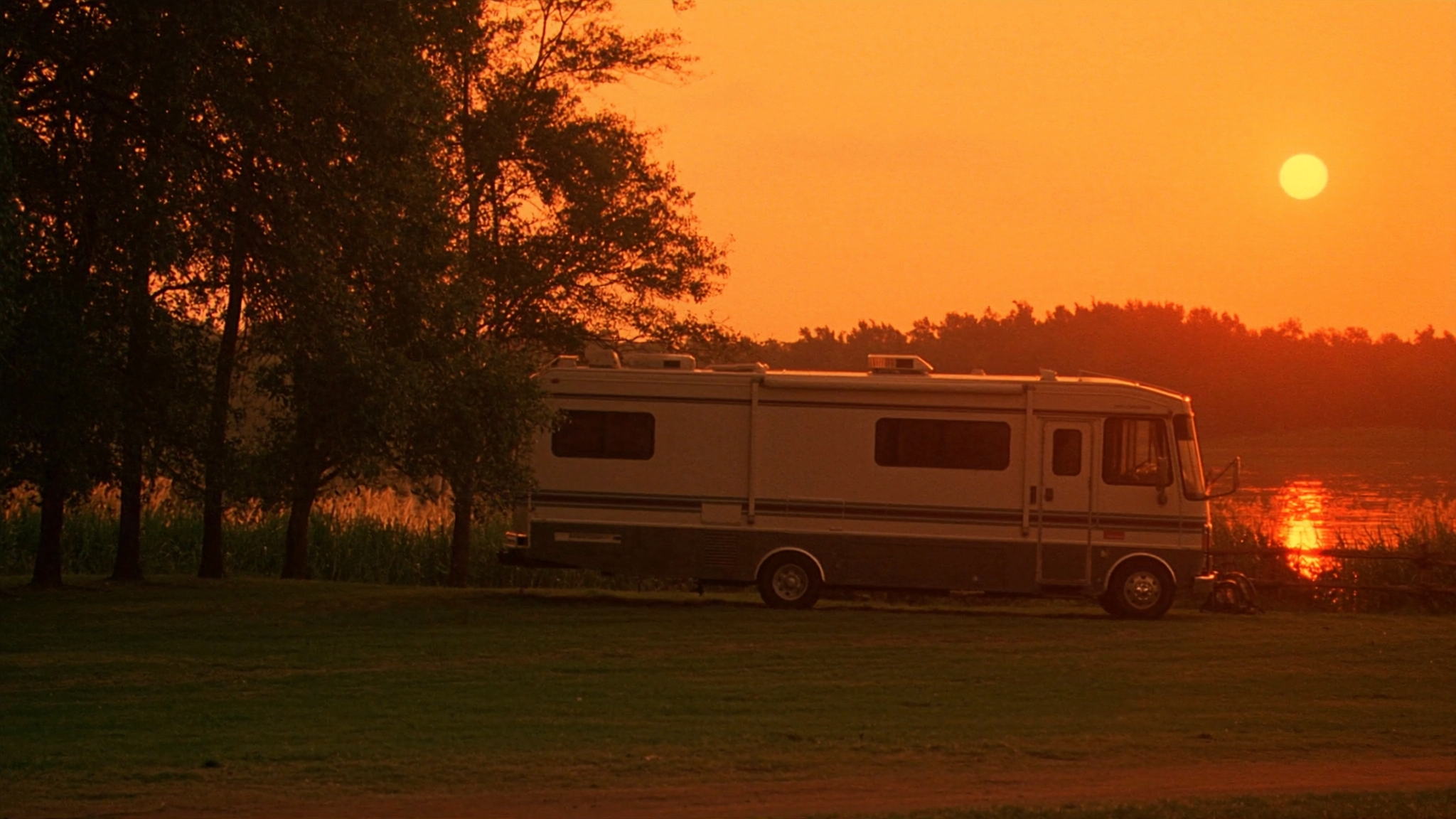 A Class A motorhome at sunset on Lake Wawasee